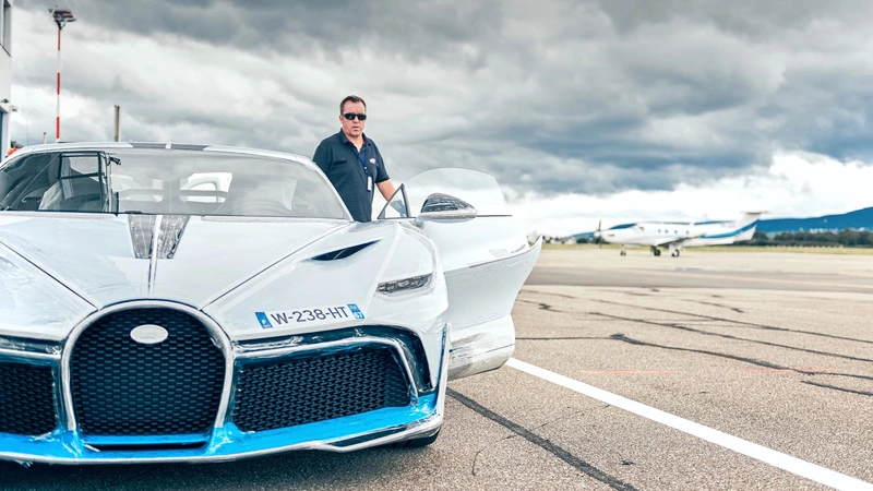 A man in a new Bugatti automobile.